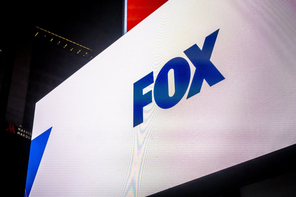 FOX logo displayed on a large digital billboard in a city entertainment district.