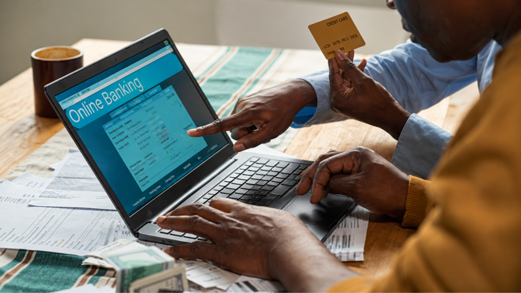 People viewing online banking on a laptop with a credit card.