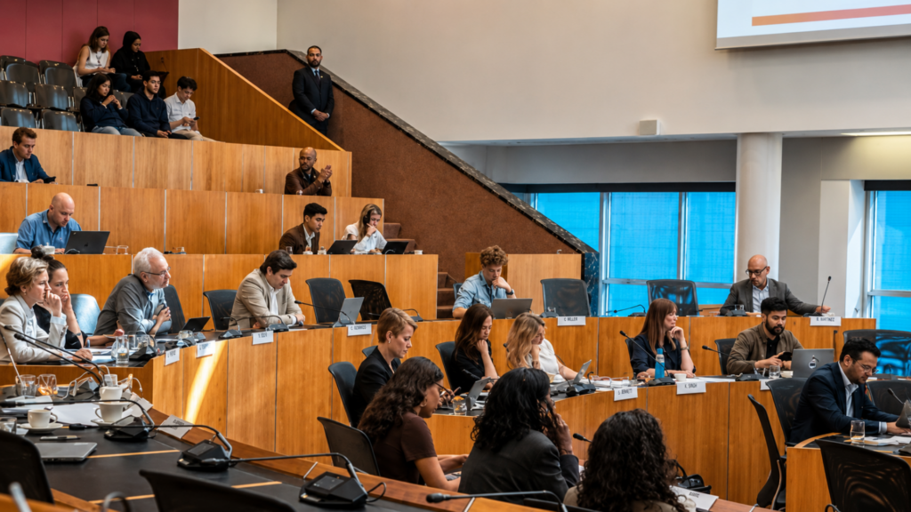 A view of local government officials and attendees participating in a public city council meeting.