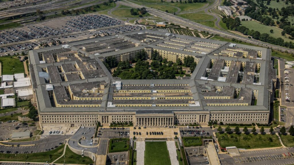 Aerial view of the Pentagon showing its five sided layout, central courtyard, surrounding parking lots, and nearby highways.