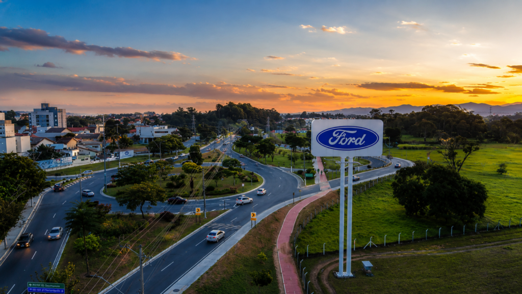 Ford sign overlooking a roadway at sunset.