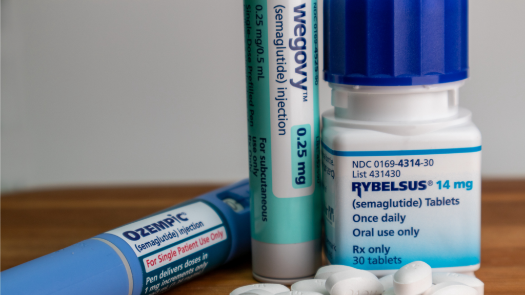 A close-up of semaglutide weight-loss and diabetes medications, including an Ozempic pen, a Wegovy pen, and a bottle of Rybelsus tablets.