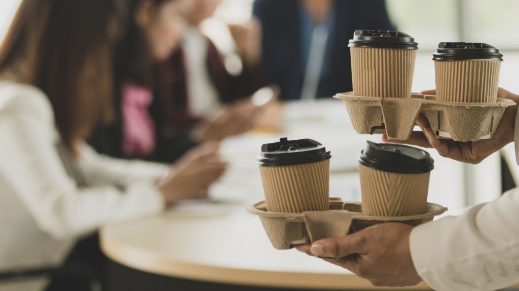 Employee and coworkers sharing coffee together, enjoying a friendly conversation and a relaxed moment in the office.