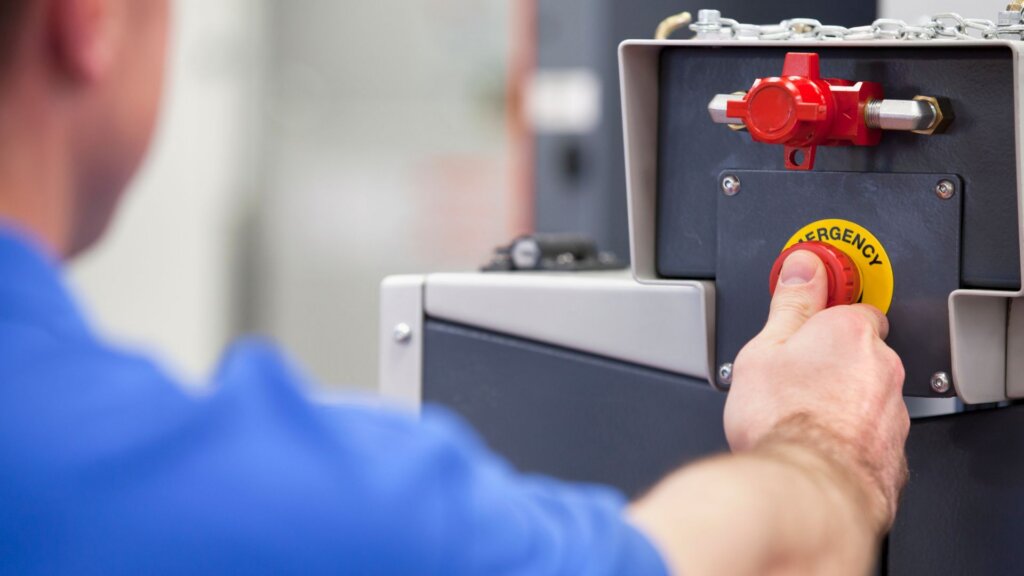 An emergency kill switch mounted on a wall, moments away from being pressed by someone.