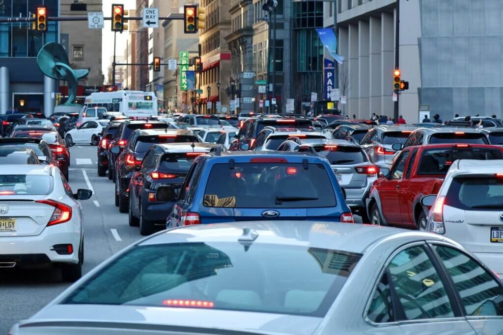Heavy Traffic Could Be Linked to Higher Neighborhood Crimes, Study Finds Heavy traffic fills a downtown street at a signalized intersection during rush hour.