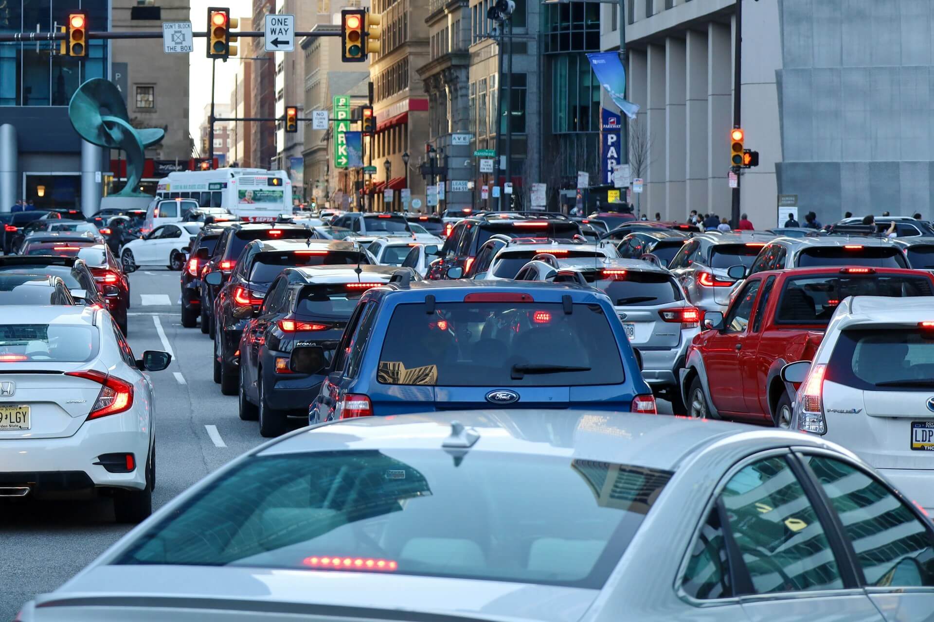 Heavy traffic fills a downtown street at a signalized intersection during rush hour.