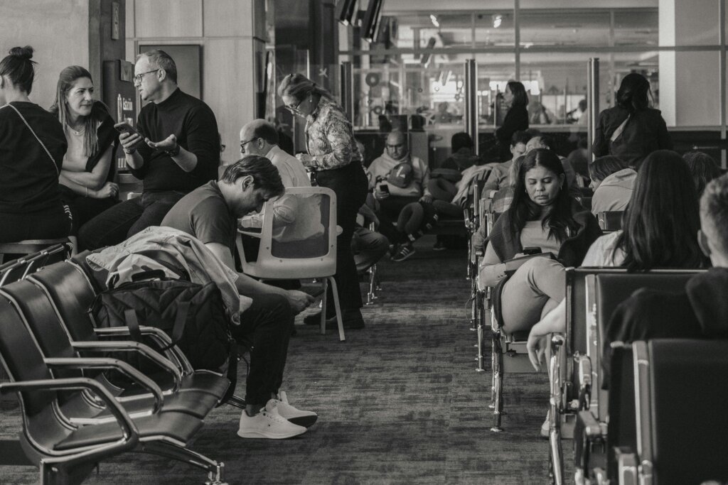 Travelers wait in an airport terminal, representing passengers affected by flight delays and schedule disruptions following the temporary American Airlines ground stop.