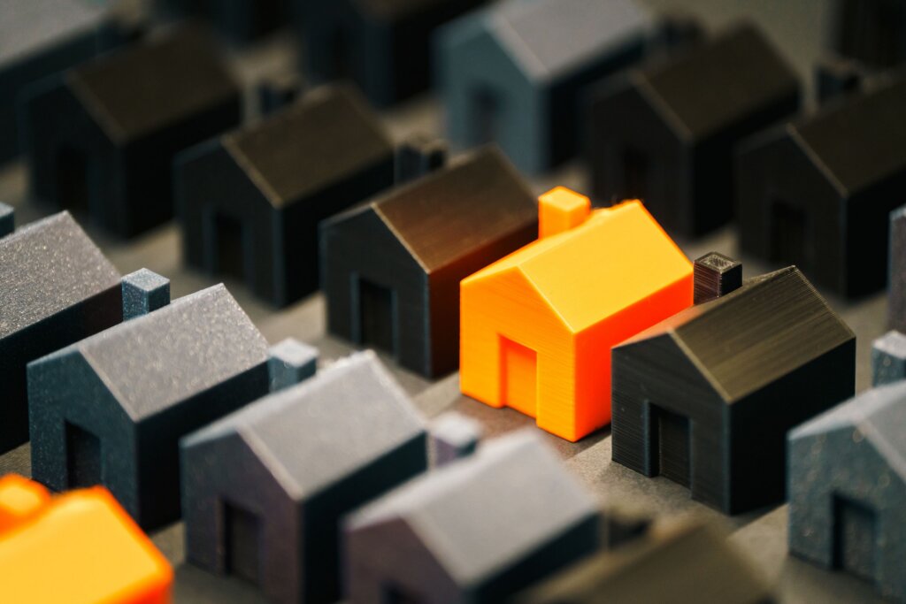 Model houses with one highlighted in orange to represent a residential property.