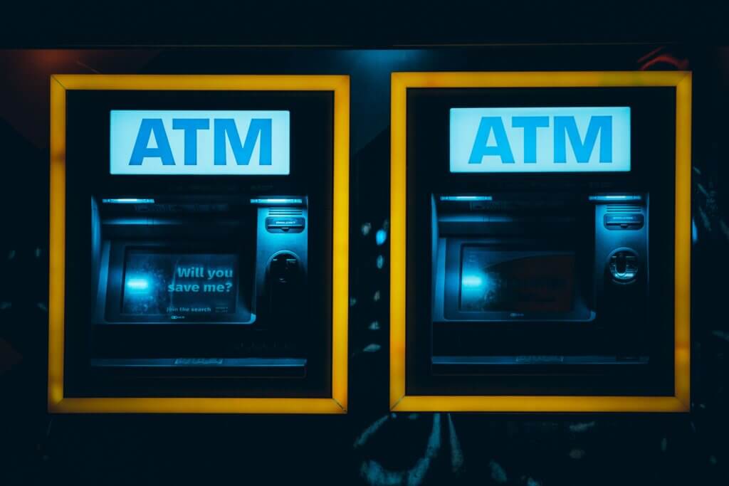 Two automated teller machines (ATMs) illuminated at night.