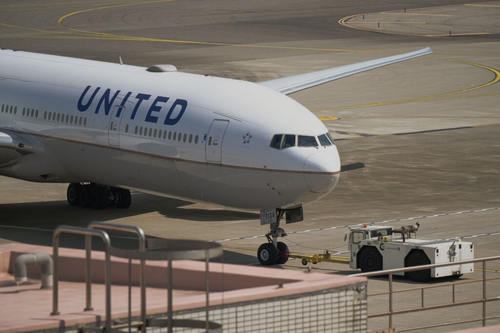 United Airlines aircraft being towed across the airport tarmac before departure.