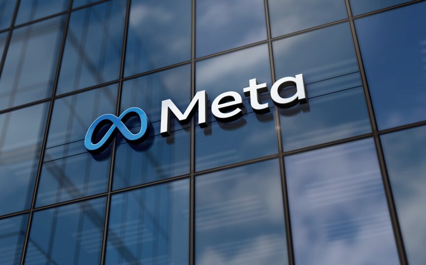 Meta logo mounted on the glass exterior of a company office building.