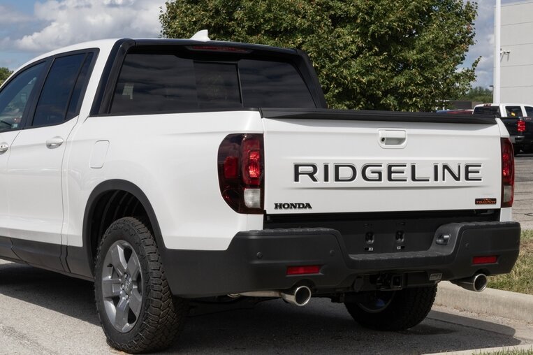Rear three-quarter view of a white Honda Ridgeline pickup truck.