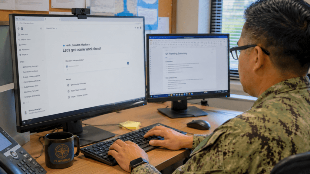 A person in a military uniform typing on a computer keyboard while using ChatGPT at a desk setup.
