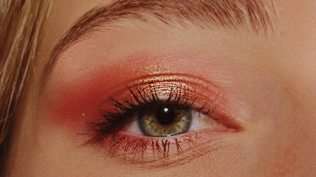 Woman’s eyes with pink and gold eyeshadow catching the light, a softer update on the shimmery '80s eye