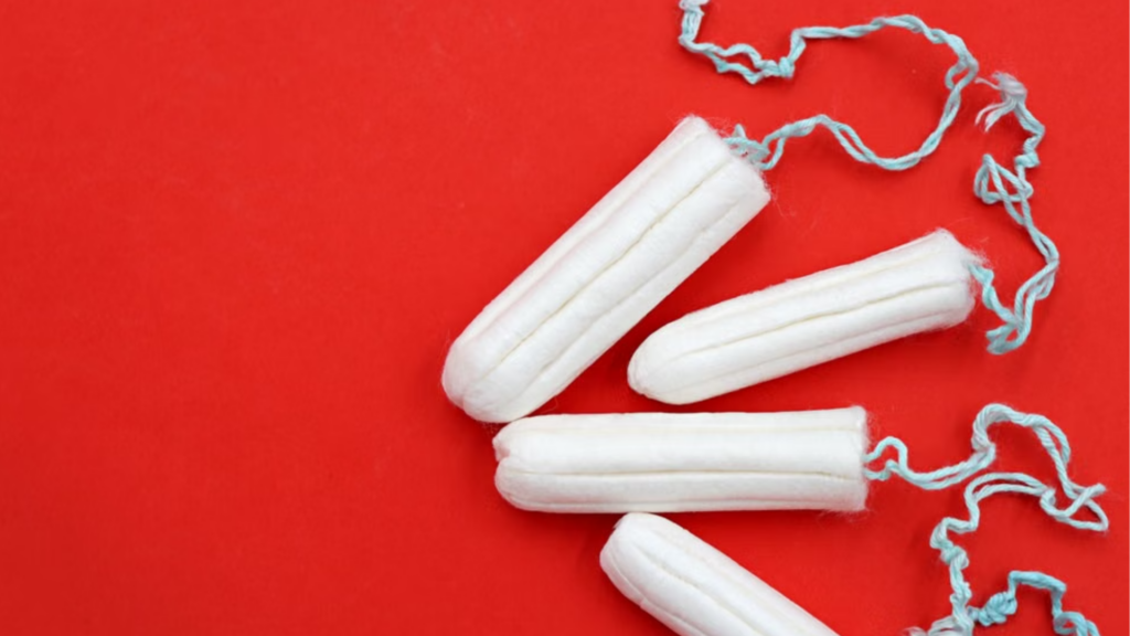 Four unrolled, non-applicator cotton tampons with blue strings fan out against a bold red background.