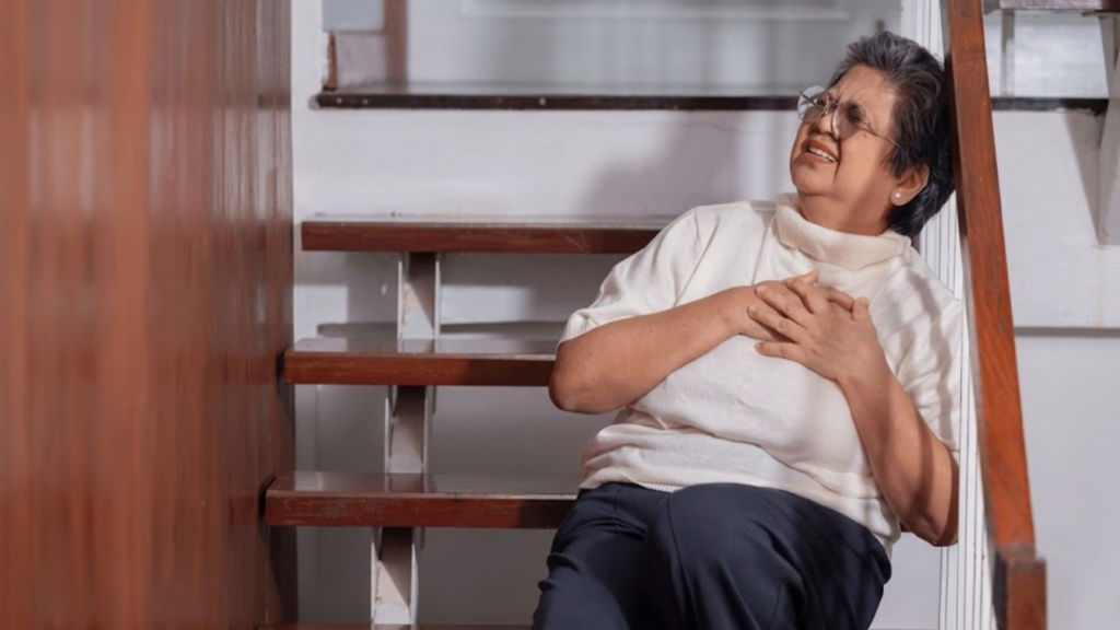 Elderly woman grab his chest with hand suffer from chest pain on the stair.