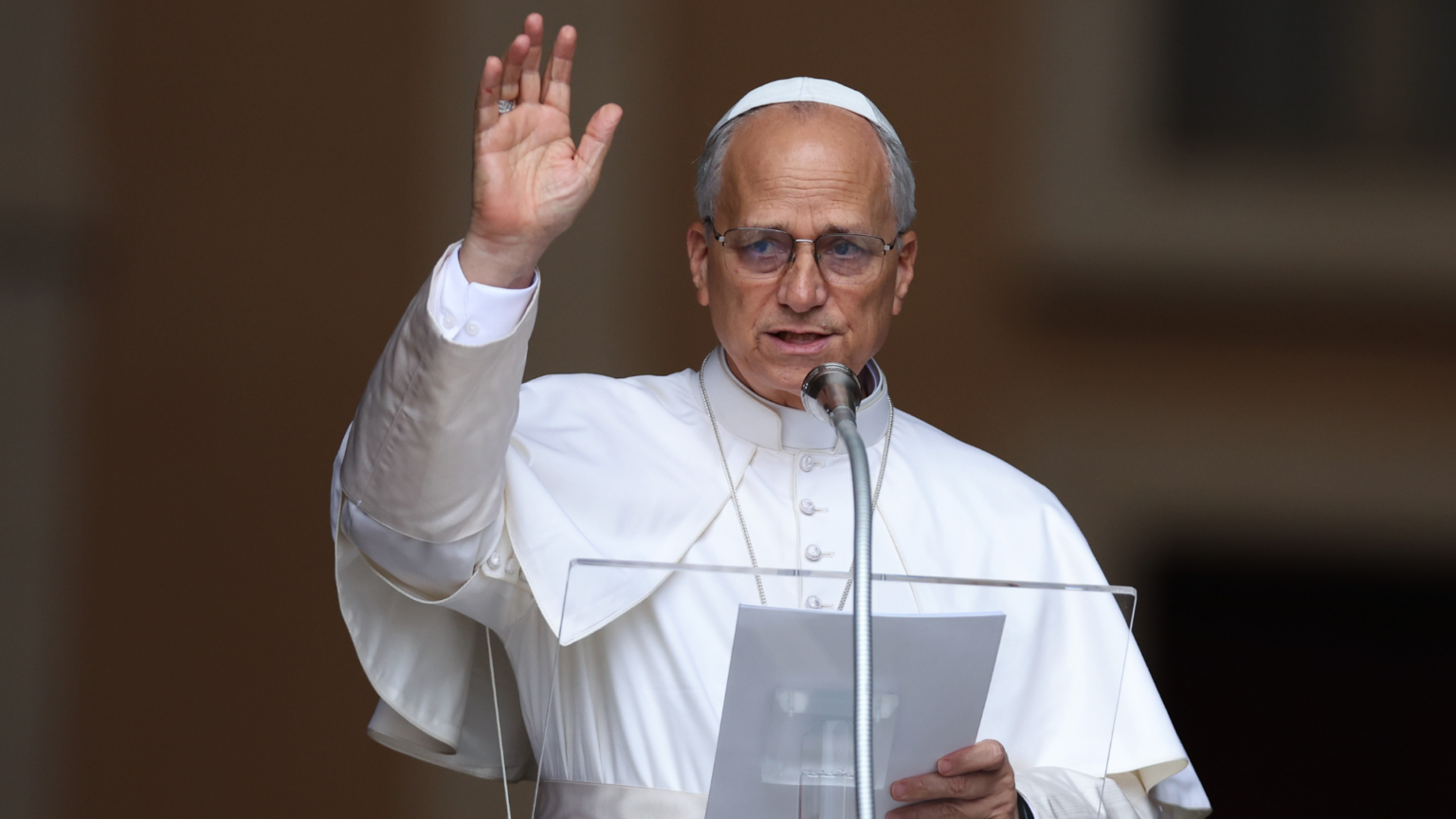 “I Entrust Myself to Your Prayers,” Pope Leo Says as He Prepares for Lung Surgery Pope Leo XIV waving while speaking at a podium.
