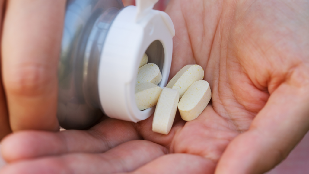 Pouring magnesium pills into an open palm.
