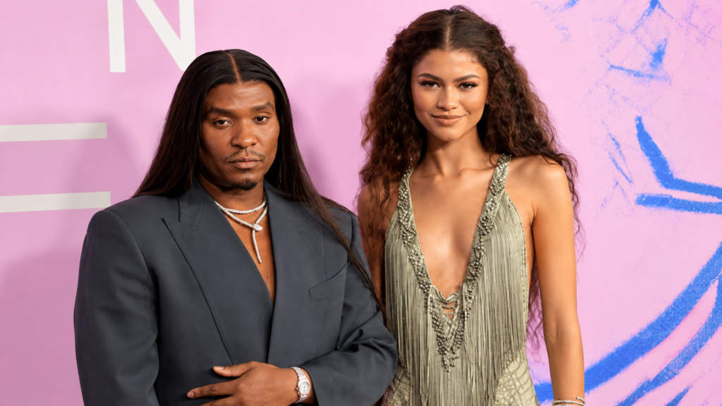Actress Zendaya in a fringed gown posing alongside celebrity stylist Law Roach at an event.