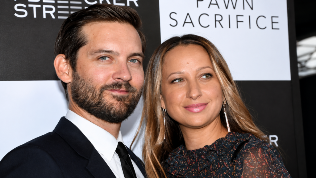Tobey Maguire with a short beard posing next to his ex-wife Jennifer Meyer at a film premiere event.