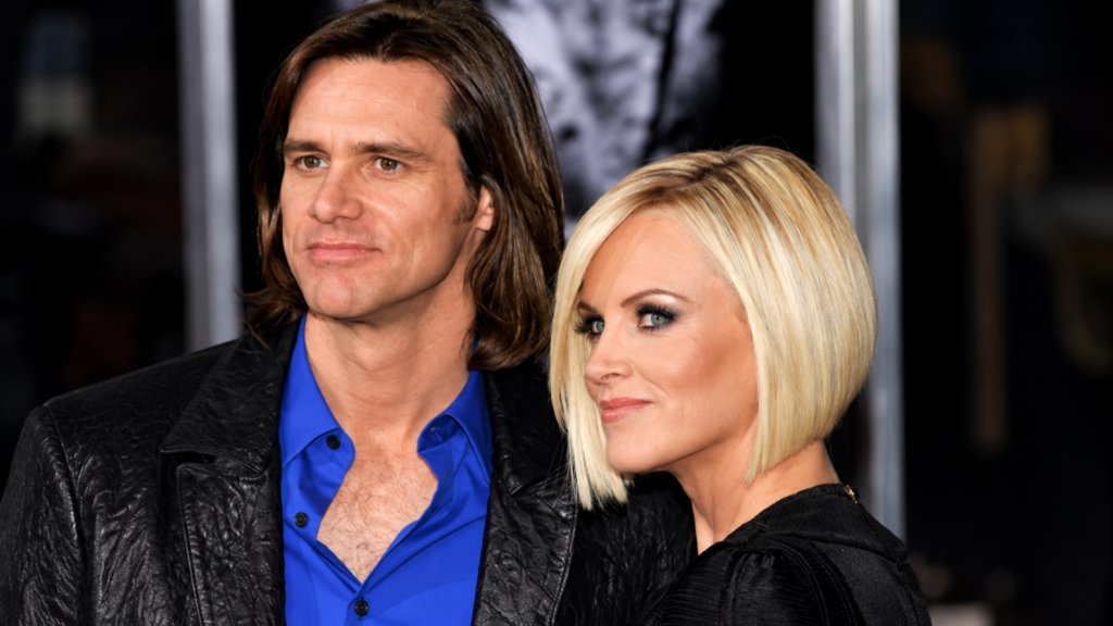 Actor Jim Carrey posing on a red carpet alongside blonde television personality Jenny McCarthy.