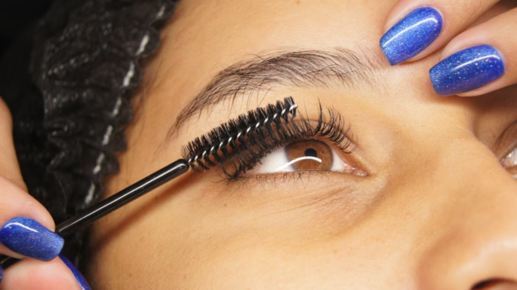 Brushing false eyelashes with a spoolie brush.