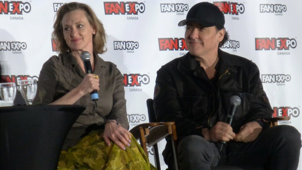 Joan Cusack and John Cusack sit together holding microphones during a Fan Expo Canada panel.
