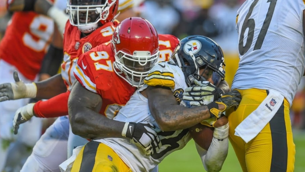 Kansas City Chiefs defensive end Allen Bailey (97) wraps up Pittsburgh Steelers running back Le'Veon Bell (26) for a short gain during the NFL Football Game.