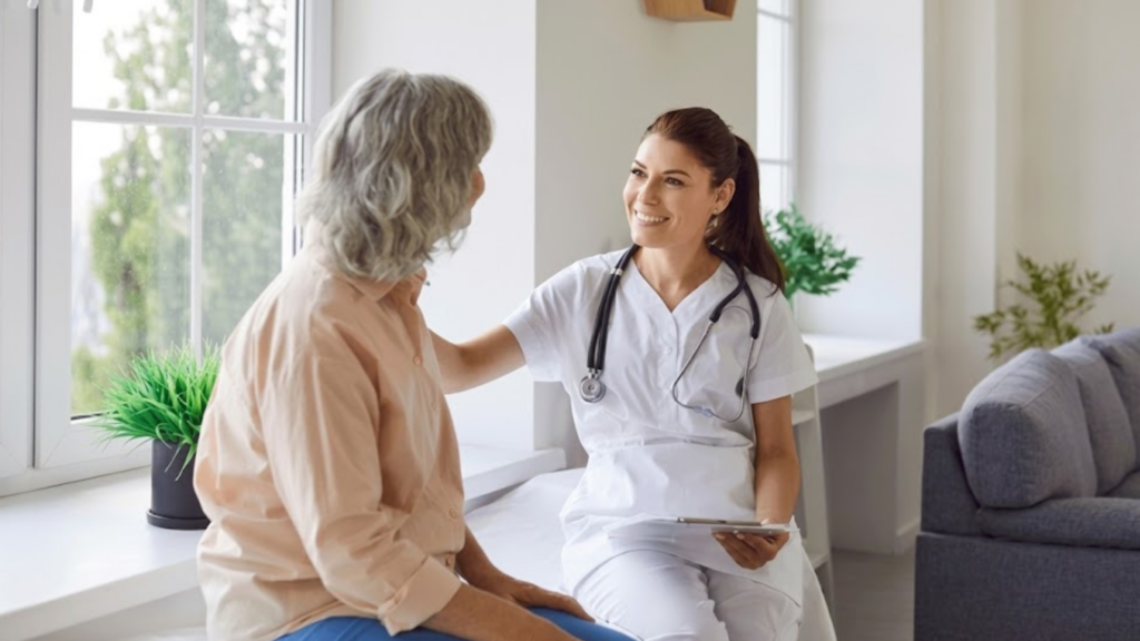 Senior woman patient in medical clinic talking with female doctor wearing stethoscope sitting on couch in office during examination. Doctor support and health care concept.