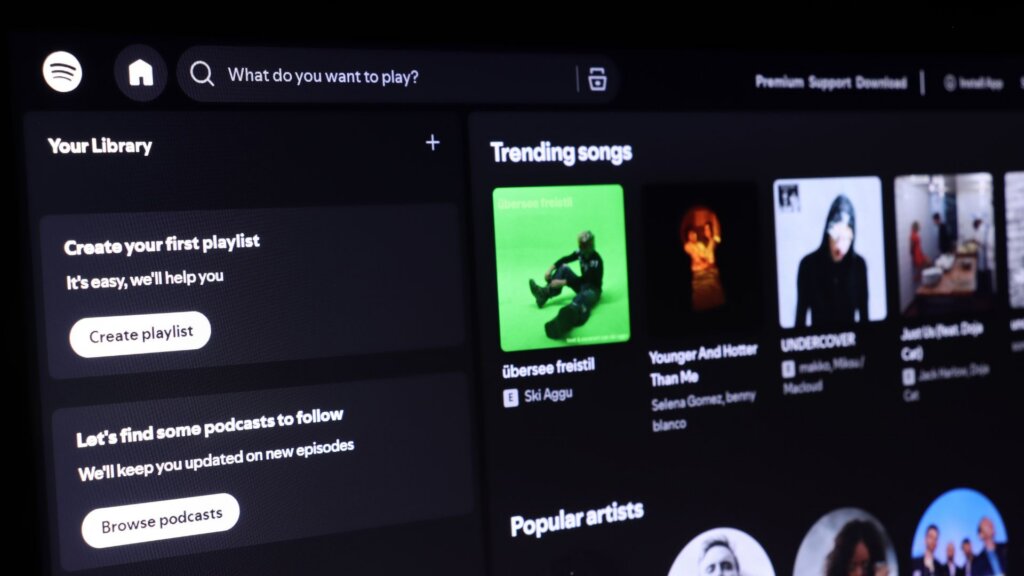 Music streaming app screen showing trending songs and popular artists.