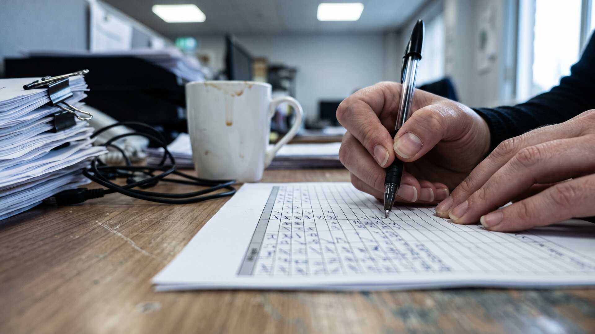 A researcher's desk mid-task with a paper coding sheet and tally marks, standing for the manual scoring of 38 videos described in this slide.