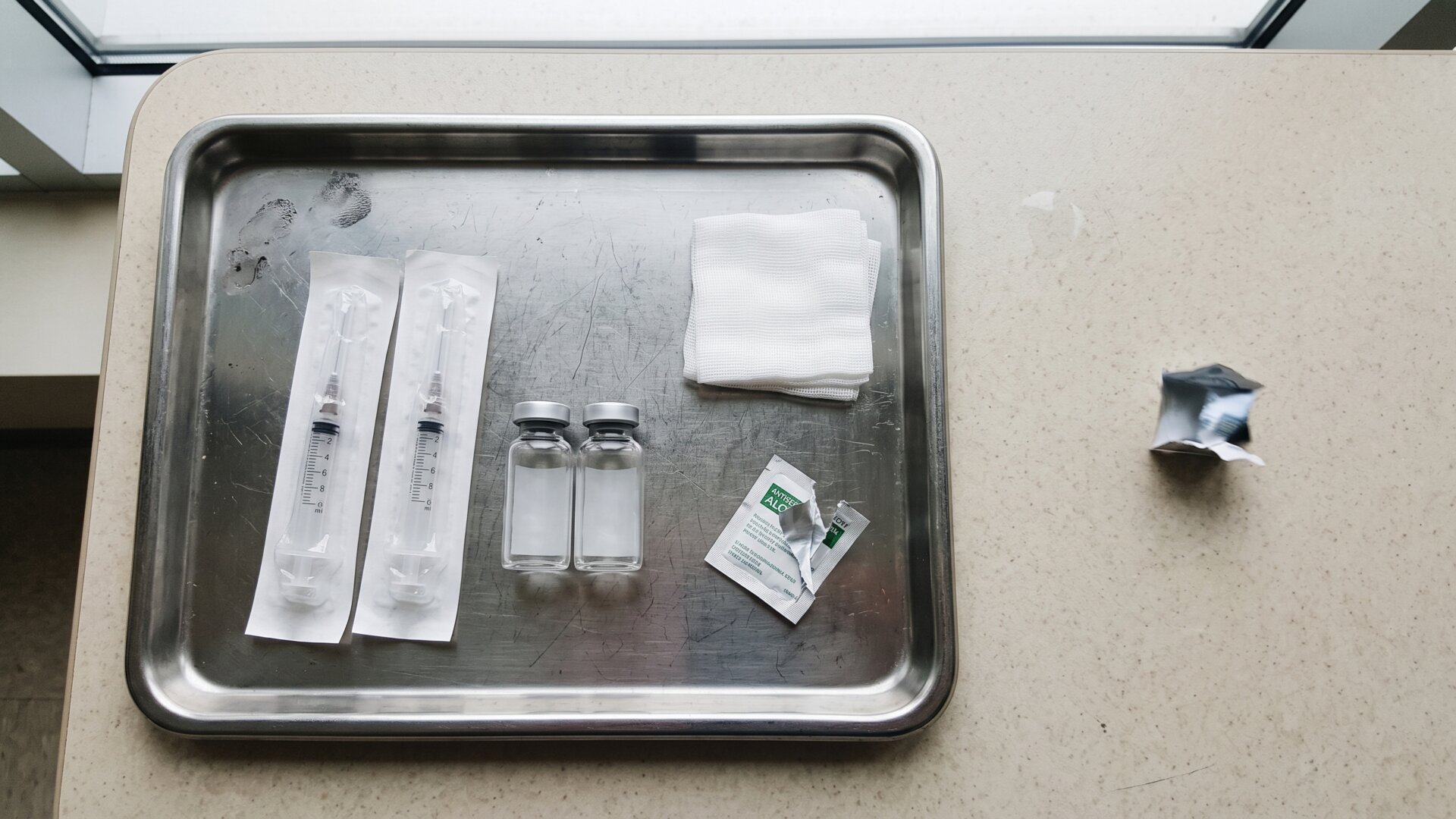 A clinical tray of unmarked injection supplies, matching slide 2's point that PDRN's documented effects come from injection rather than topical use.