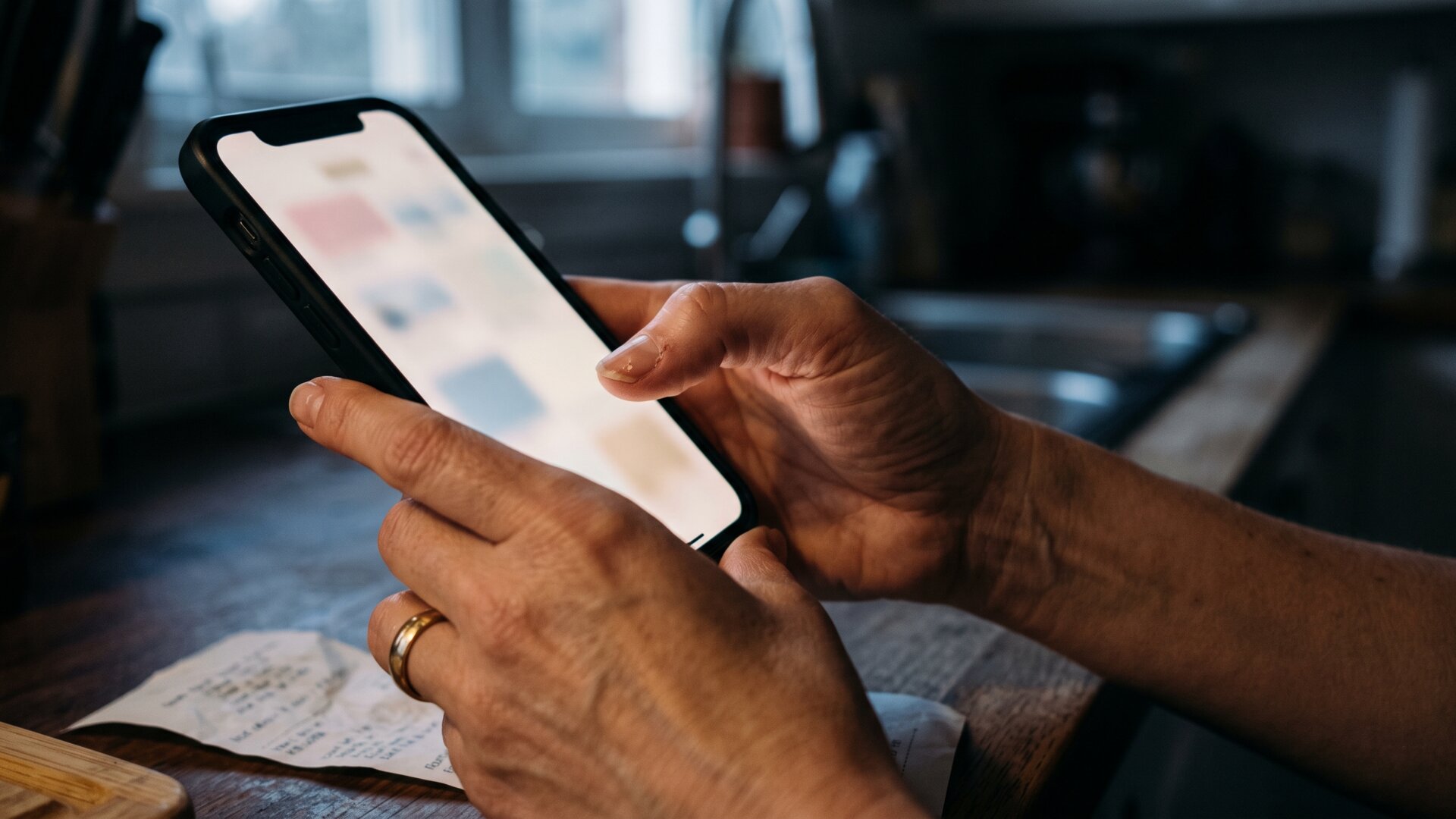 Hands holding a phone displaying abstract non-textual shapes, standing in for the reverse-engineering habit slide 7 describes without rendering any real person or post.