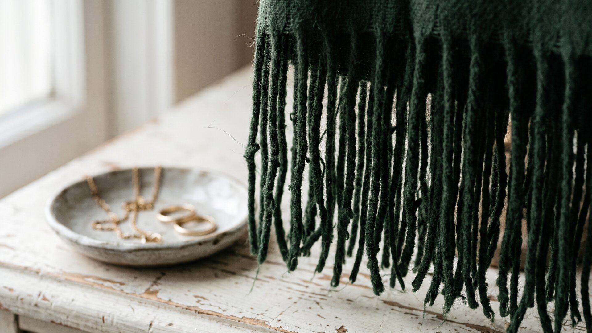 Heavy fringe filling the frame with jewelry set aside on a dish, the competition for attention slide 7 asks readers to resolve.