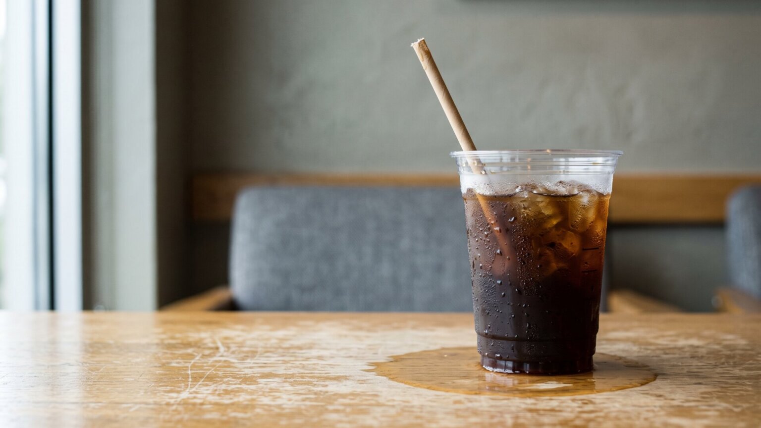 A plastic iced coffee cup sweating on an office reception table, the physical object the entire debate formed around.