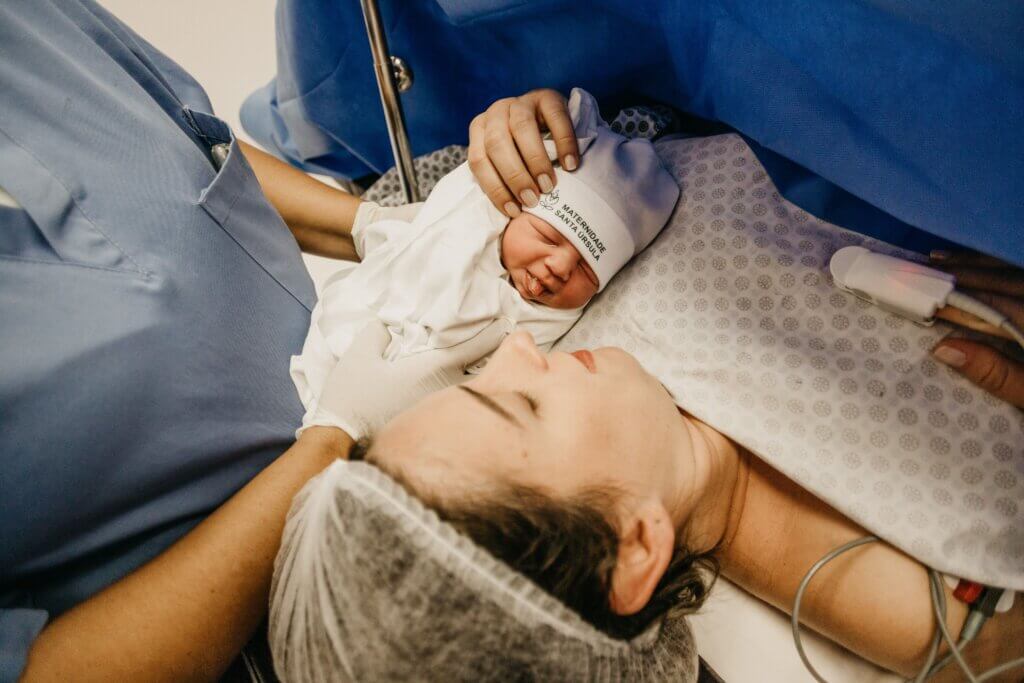 Newborn baby placed on the mother's chest immediately after delivery in a hospital maternity ward.